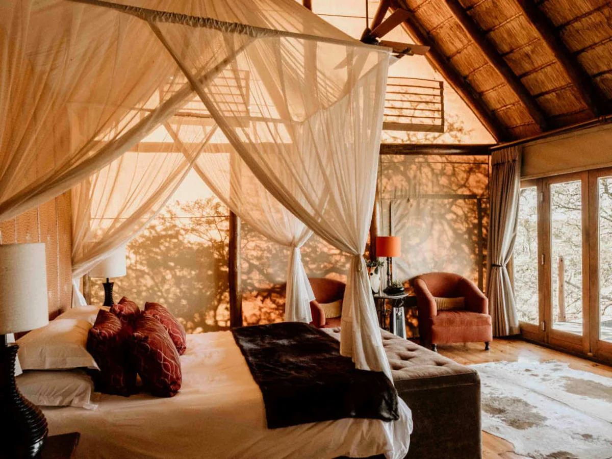 Bush Lodge main building at twilight — warm light spilling onto the deck