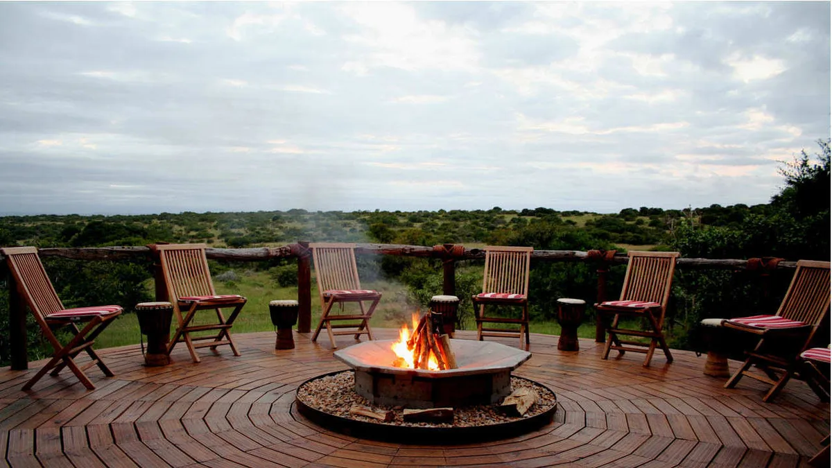 Outdoor boma fire pit with safari chairs and panoramic bushveld view