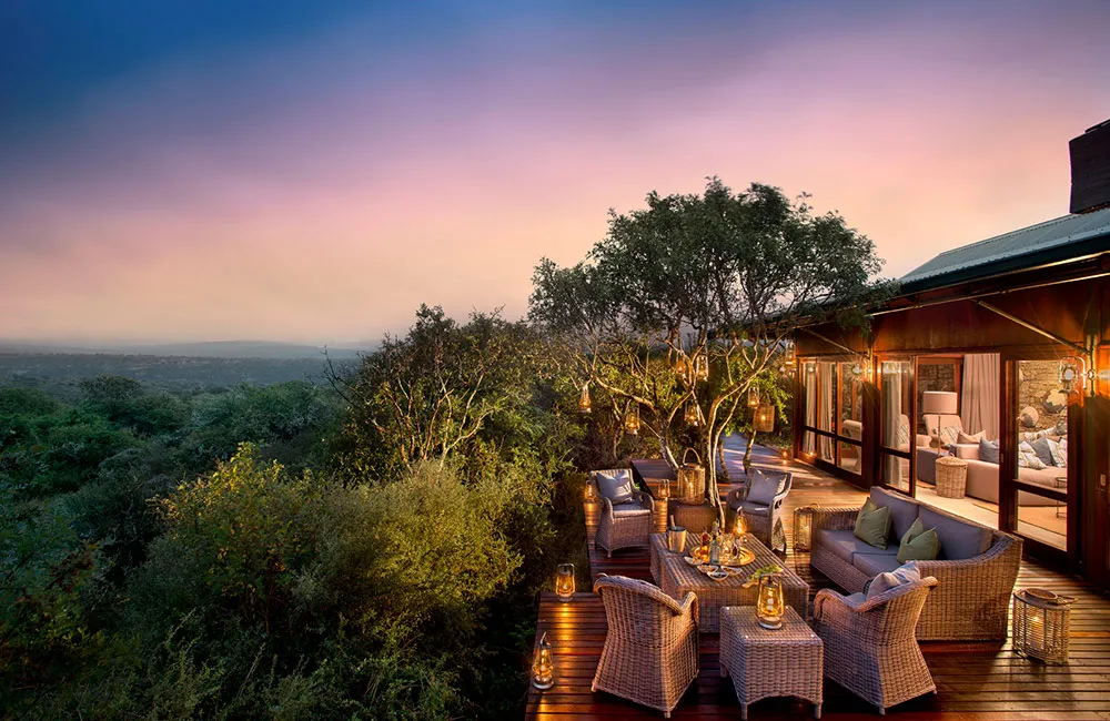 Twilight viewing deck with lantern-lit tree overlooking the Kwandwe valley