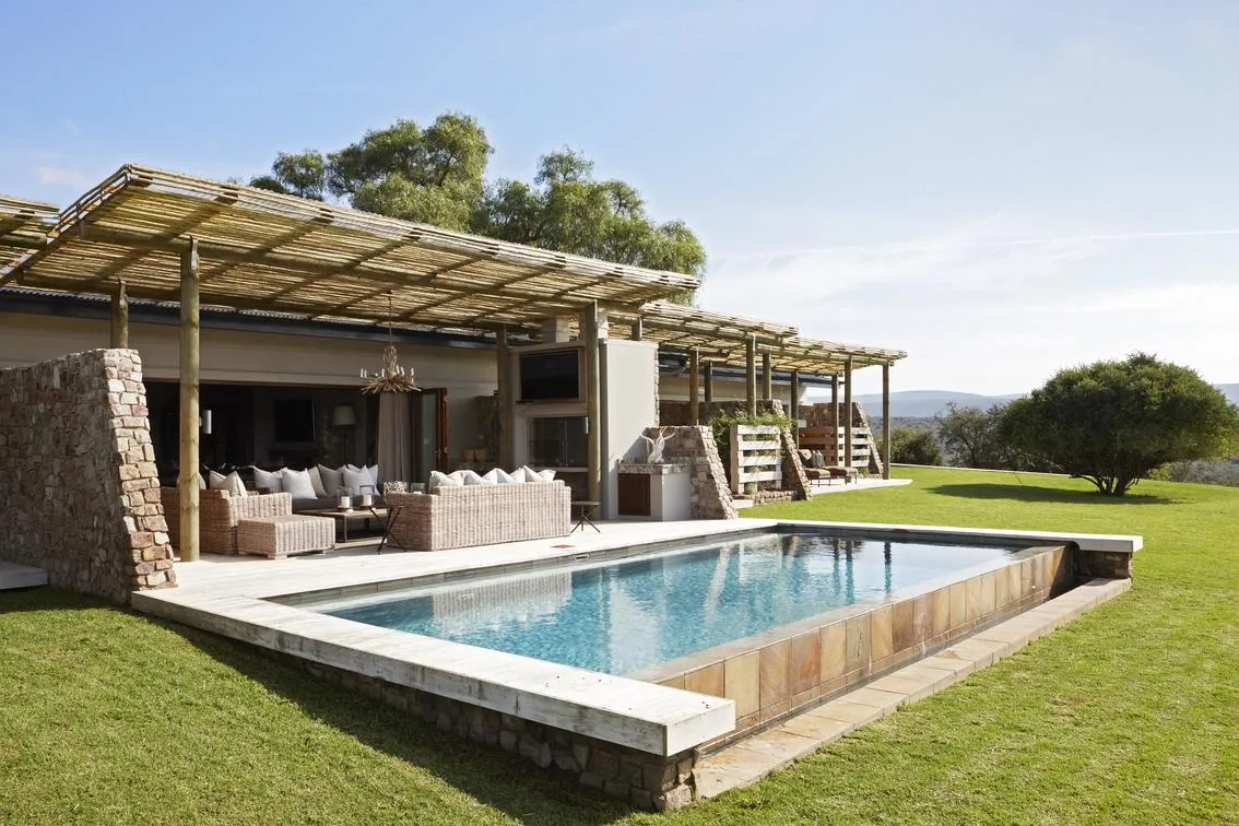 Reed-shaded pool deck with cushioned lounge area overlooking the valley