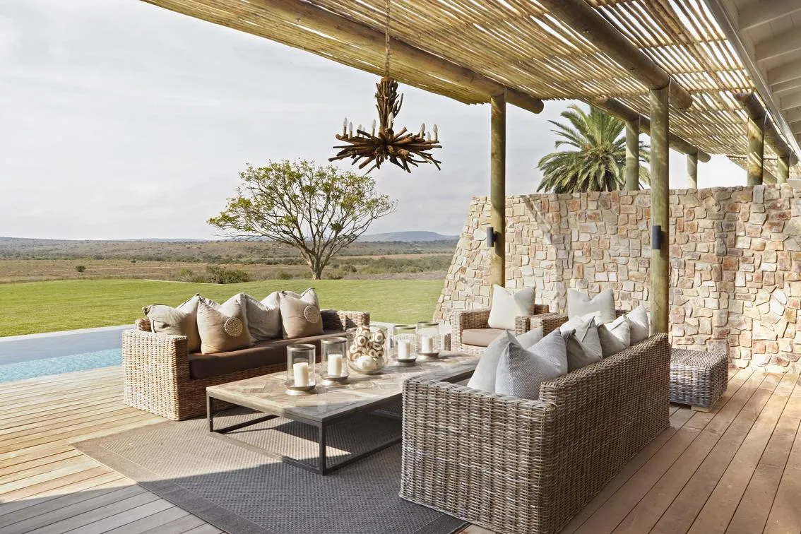 Covered outdoor lounge with stone wall and plain views