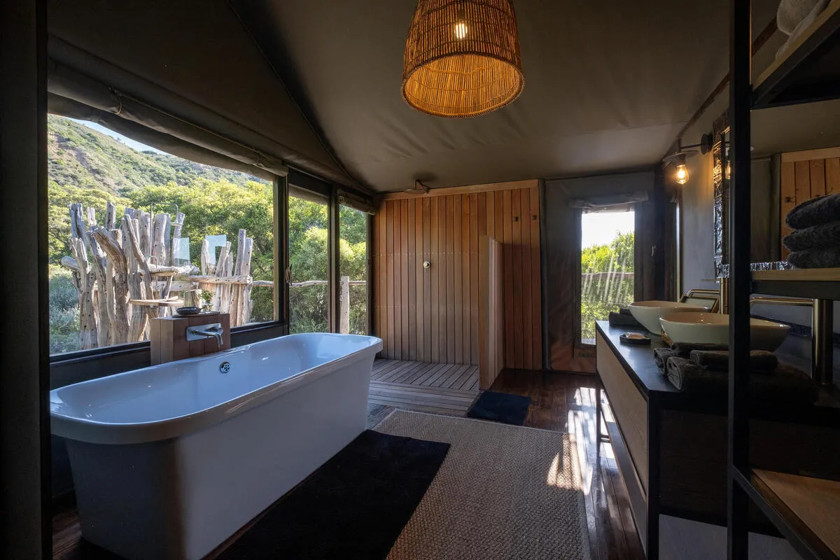 En-suite bathroom with freestanding tub and floor-to-ceiling windows onto the valley