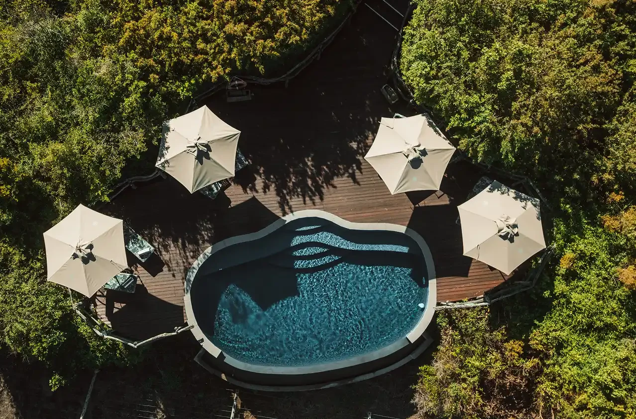 Mark's Camp pool deck with shaded umbrellas