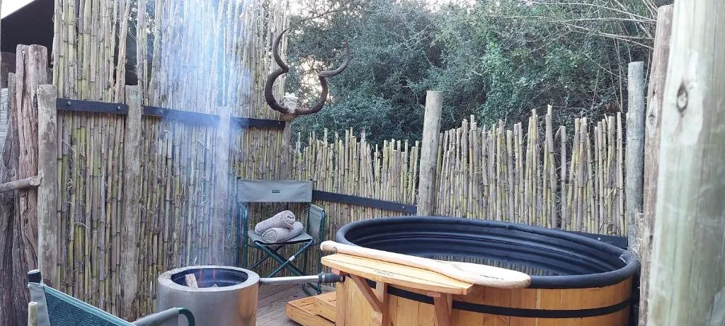 Outdoor wood-fired hot tub with bamboo screen and mounted antelope horns