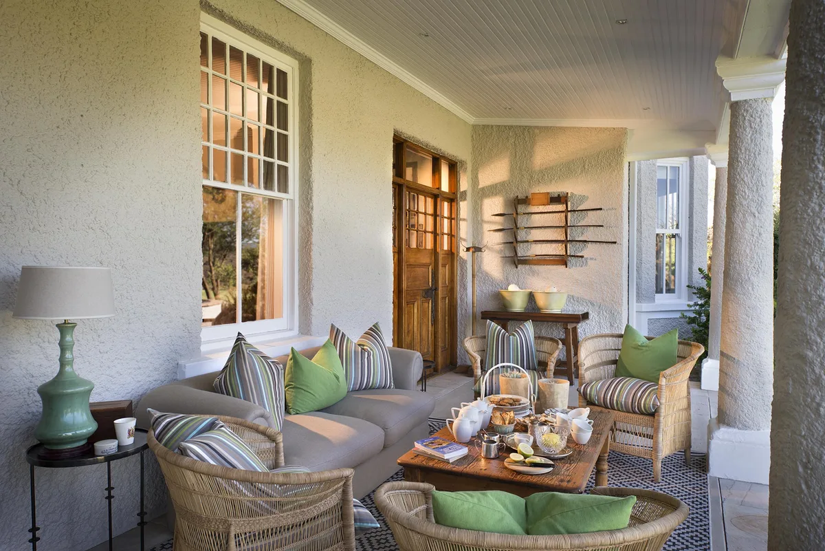 Covered veranda with breakfast tray, green cushions and bushveld view