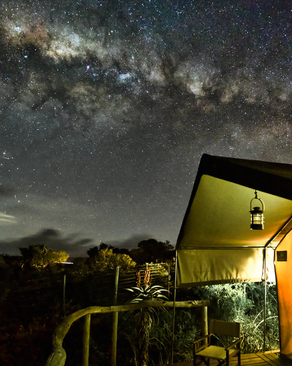 Milky Way over a glowing Woodbury safari tent at night
