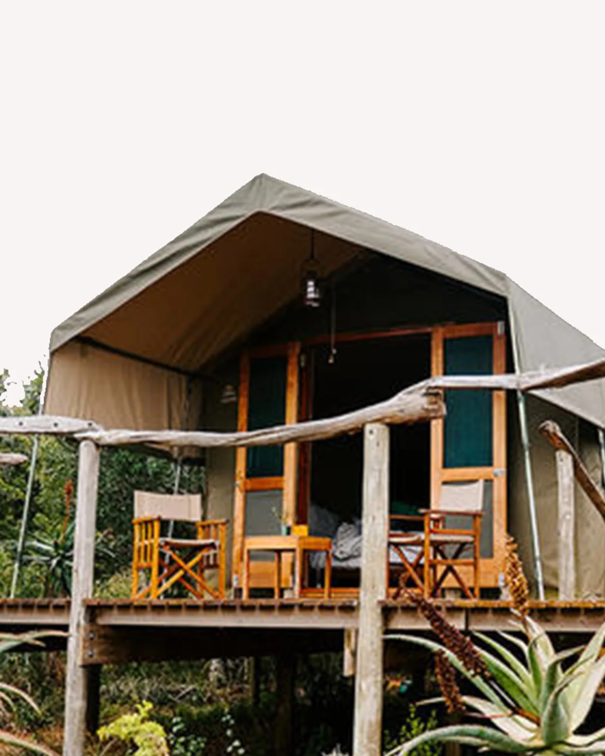 Canvas safari tent on raised wooden stilts with director's chairs on the deck