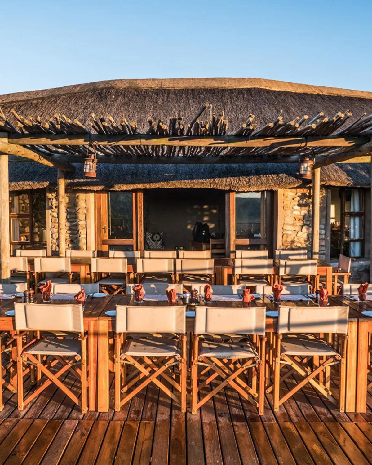 Bar and dining boma at golden hour with safari chairs lined up